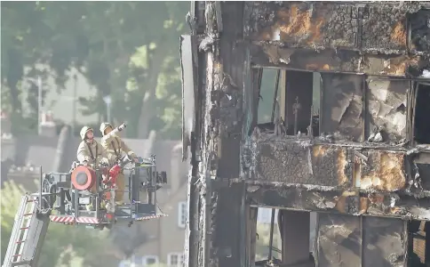  ??  ?? Firefighte­rs use a hydraulic lift to inspect the Grenfell Tower block in north Kensington, West London, Britain. — Reuters photo