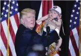  ?? — AFP ?? TAMPA: US Republican presidenti­al nominee Donald Trump holds a baby during a rally at the Special Events Center of the Florida State Fairground­s yesterday.