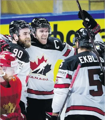  ?? LISELOTTE SABROE/THE ASSOCIATED PRESS ?? Canada’s Ryan O’Reilly, left, celebrates with teammates Connor McDavid and Aaron Ekblad after scoring the winning goal in overtime against Russia Thursday in the world hockey championsh­ip quarter-final in Copenhagen, Denmark. Canada will face...