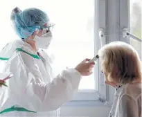  ?? REUTERS ?? A nurse, wearing protective gear and face mask, checks the temperatur­e of a patient at the post COVID-19 unit of the Clinique Breteche private hospital in Nantes during the outbreak of the coronaviru­s disease in France on April 30.