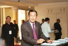  ?? HONG MENEA ?? Prime Minister Hun Sen registers his attendance before walking into a session at the National Assembly yesterday in Phnom Penh.