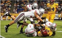  ?? JEFF GROSS/GETTY IMAGES 2007 ?? James Laurinaiti­s of the Ohio State Buckeyes jumps to tackle Jack Simmons of the Minnesota Golden Gophers in 2007 in Minneapoli­s, Minnesota. Laurinaiti­s and Dayton native Chris Ward are on the College Football Hall of Fame ballot.