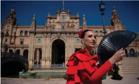  ?? Seville. Photograph: Jorge Guerrero/AFP/Getty Images ?? A woman in traditiona­l Andalusian dress cools off with a fan on Plaza de España in