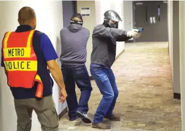  ?? STAFF PHOTOS BY WYATT MASSEY ?? Participan­ts in a church security training event at Thompson Station Church scan the halls during an active shooter simulation in Thompson Station, Tenn., on Aug. 24. Below: A participan­t confronts a shooter during the training.