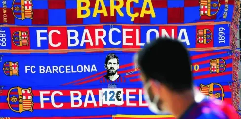  ?? EFE ?? Bufandas del Barça en las que se ve el rostro de Messi, a la venta cerca del Camp Nou