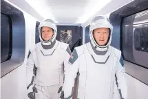  ?? SPACEX VIA AP ?? NASA astronauts Bob Behnken, left, and Doug Hurley, wearing SpaceX spacesuits, walk through the Crew Access Arm connecting the launch tower to the SpaceX Crew Dragon spacecraft.