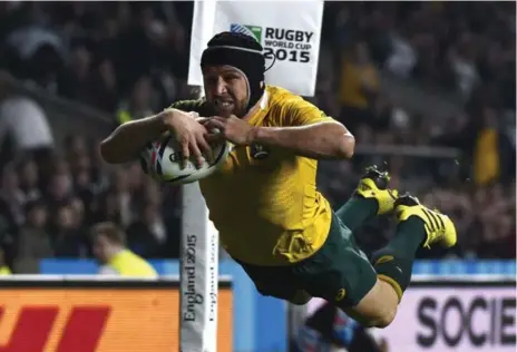  ?? LOIC VENANCE/AFP/GETTY IMAGES ?? Australia’s centre Matt Giteau soars soars through the air to score his team’s third try during Rugby World Cup play against England on Saturday.