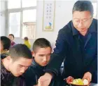  ?? Photos: Handouts ?? Liu Aiye wheels a student to class in her wheelchair at the school he created; and Liu serves free meals to his students.