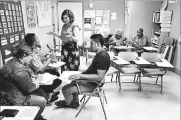  ?? CHRIS WALKER/CHICAGO TRIBUNE ?? Sarah Glazer, standing, teaches an English-language class at RefugeeOne, one of the larger resettleme­nt agencies in Chicago.