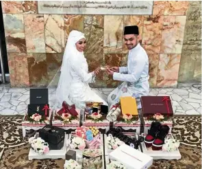  ??  ?? Blissful union: Muaz putting the wedding ring on Errina after the solemnisat­ion ceremony.