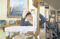  ?? JULIE JOCSAK/POSTMEDIA NEWS ?? Michelle Morrissey is photograph­ed by a chair she has decorated in her Ridgeway studio for the Chair Affair Auction that will raise funds for the Niagara Furniture Bank on Thursday.