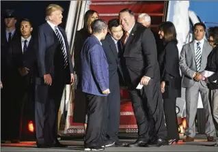  ?? DOUG MILLS / NYT ?? As President Donald Trump looks on, Secretary of State Mike Pompeo embraces Tony Kim as Kim and two other U.S. prisoners freed from North Korea arrive at Joint Base Andrews, Md., on Thursday.