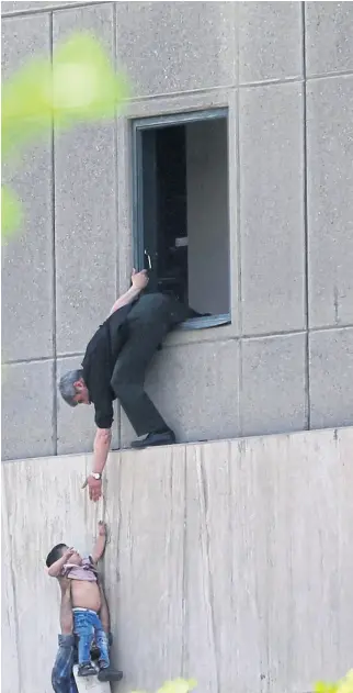  ??  ?? Las fuerzas de seguridad evacuan a un chico en el Parlamento iraní