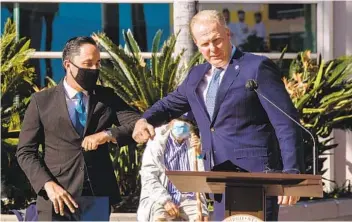  ?? ARIANA DREHSLER ?? After Mayor Kevin Faulconer (right) introduces Mayor-elect Todd Gloria, he gives him an elbow bump before speaking about “Operation Shelter to Home” in front of the San Diego Convention Center on Tuesday.