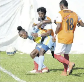  ??  ?? The Dunbeholde­n FC pair of Demareo Phillips (centre) and Narado Brown (right) sandwich Waterhouse FC’S Ricardo Thomas during the Red Stripe Premier League game at Royal Lakes Complex yesterday. The game ended 0-0.