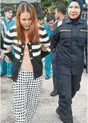  ??  ?? “陆地舵公”越南籍女被告（左）在女警员的押送下到丰­盛港推事庭面控。