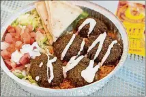  ?? CONTRIBUTE­D BY MIA YAKEL ?? Halal Guys’ falafel platter with rice, lettuce, tomato, grilled pita, and special white sauce.