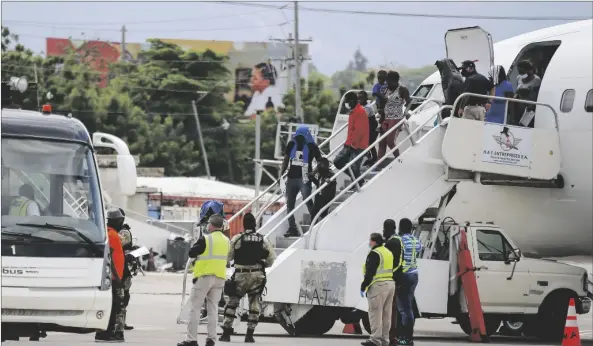  ?? AP PHOTO/ODELYN JOSEPH ?? Haitians who were deported from the United States deplane at the Toussaint Louverture Internatio­nal Airport, in Port au Prince, Haiti, on 2021.
