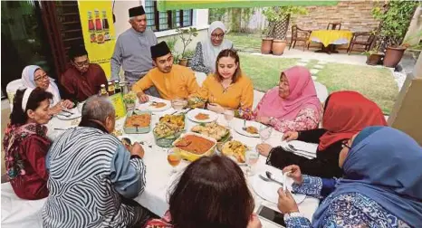  ?? [FOTO OWEE AH CHUN/BH] ?? Mariah (berdiri kanan) dan suami, Shaharudin Shamsudin bersama cef Fikree (duduk lima dari kanan) dan tetamu pada program Jamuan Raya Kimball bersama Chef Fikree di Kampung
Tengah A, Puchong, semalam.