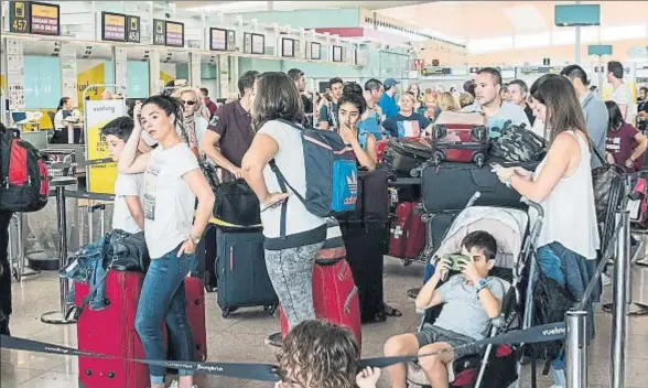  ?? GEMMA MIRALDA ?? Los pasajeros haciendo cola en los mostradore­s de Vueling en el aeropuerto de El Prat
