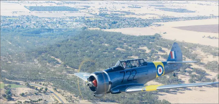  ??  ?? WEARY WARBIRD: Pilot Nick Caldwell wheels Wirraway A20-722 across the sky above the west Wimmera town of Nhill while navigating the aircraft to its final resting place. The Wirraway, a rare flying example of one of the planes the RAAF used at its Nhill...