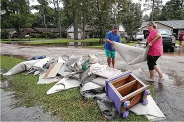  ?? Godofredo A. Vasquez / Houston Chronicle ?? Michael and Laura Gill dispose of soaked carpet Wednesday after their Baytown home flooded with about 3 feet of water during Tropical Storm Harvey, which bombarded northern parts of the suburb. “We’re still in the destructio­n phase,” said resident...