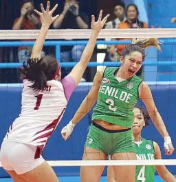  ??  ?? St. Benilde’s Marites Pablo reacts after hammering in a kill against Bianca Tripoli of Perpetual Help in their NCAA volleyball match.