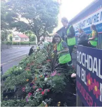  ??  ?? ●●Volunteers planting the ‘Wonderwall’ flowerbed at the Crown Oil Arena in Rochdale