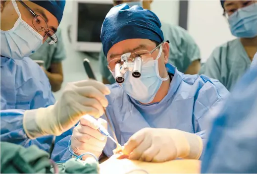  ??  ?? Dr Wu Jiong, vice president of Shanghai Cancer Center, conducts a breast reconstruc­tion operation. — Jiang Xiaowei