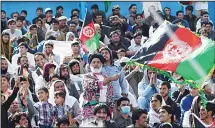  ?? (AFP) ?? In this photograph taken on Sept 18, Afghan cricket fans cheer and wave the national flags during the Shpageeza Cricket League T20 tournament at
the Kabul Internatio­nal Cricket ground in Kabul.