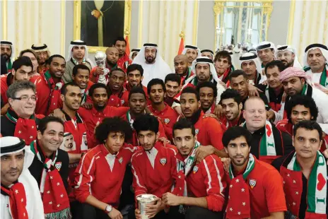  ?? Wam ?? Sheikh Khalifa meets the UAE national football team at Al Rawda Palace, Al Ain, after their 2-1 extra-time victory over Iraq in the Gulf Cup final in Bahrain in 2013. Emirati footballer Ismail Matar, holding the trophy, has paid tribute to the late leader