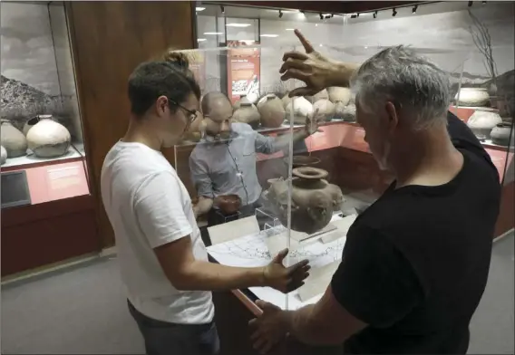  ?? COURTESY PHOTOS ?? Museum staff placing the lid on the new case that will showcase ceramics from the IVC Archeology collection that are not typically seen on the exhibit floor.