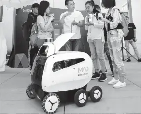  ?? PROVIDED TO CHINA DAILY ?? Customers drink coffee delivered by Meituan-Dianping’s autonomous driving car in Xiongan New Area in northern China’s Hebei province on Sept 7.