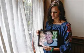  ?? CURTIS COMPTON / CCOMPTON@AJC.COM ?? Mandi Sorohan poses for a portrait with a picture of her son, Caleb, at her office Thursday in Madison. Sorohan has been fighting for tougher distracted driving laws in Georgia since Caleb died in an accident while texting in 2009.