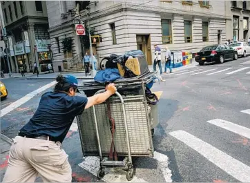  ?? Drew Angerer Getty Images ?? THE IMPROVEMEN­T for the hard-to-employ has been relatively small and spotty, confined mostly to places with exceedingl­y low unemployme­nt. Above, a worker pushes a cart full of supplies through New York City.