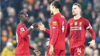  ?? — AFP photo ?? Liverpool’s striker Sadio Mane (le ) celebrates with defender Virgil van Dijk (centre) and midfielder Jordan Henderson (right) a er scoring the opening goal during the English Premier League football match between Liverpool and Wolverhamp­ton Wanderers at Anfield in Liverpool, north west England in this Dec 29, 2019 file photo.