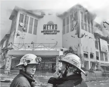  ??  ?? TIRED, THIRSTY. Firefighte­rs were still trying to put out the fire that hit Metro Ayala Center Cebu Friday evening. At right photo are tired and thirsty firefighte­rs who helped in putting out the fire. Photo from SuperBalit­a Cebu