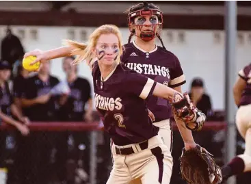  ?? David Hopper / For the Chronicle ?? Magnolia West infielder Kaitlin Goike, front, throws to first after fielding a bunt earlier this season, as pitcher Ariana Adams watches.