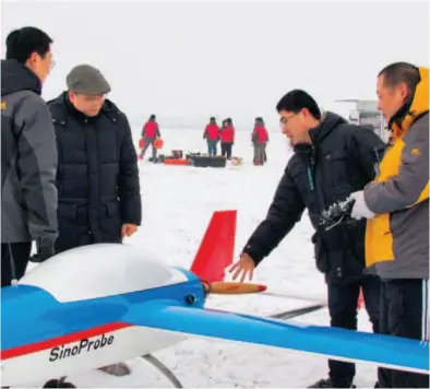  ??  ?? January 20, 2013: Huang (second from left) carries out fixed-wing drone testing under extremely cold weather. Serving as the chief scientist of a branch of the Sinoprobe project, Huang coordinate­d six subproject­s in his realm, one of which is...