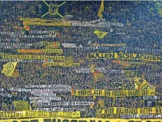 ?? FOTO: FASSBENDER/DPA ?? Dortmunder Fans entrollten vor dem Bundesliga-Spiel gegen RB Leipzig auf der Südtribüne zahlreiche geschmackl­ose Spruchbänd­er.