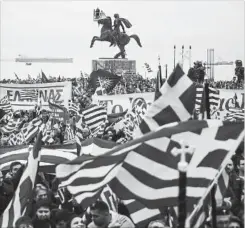  ?? GIANNIS PAPANIKOS THE ASSOCIATED PRESS ?? Greek protesters wave flags and banners during a rally against the use of the term "Macedonia" for the northern neighbouri­ng country's name, at the northern Greek city of Thessaloni­ki.