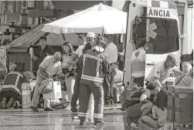  ?? Oriol Duran / Associated Press ?? Injured people are treated after a white van jumped the sidewalk, crashing into a crowd of residents and tourists in the historic Las Ramblas district of Barcelona.