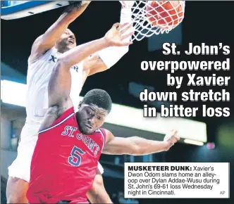  ?? AP ?? MUSKETEER DUNK: Xavier’s Dwon Odom slams home an alleyoop over Dylan Addae-Wusu during St. John’s 69-61 loss Wednesday night in Cincinnati.