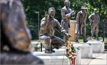  ?? NICK GRAHAM — THE JOURNAL-NEWS VIA AP ?? A wreath is displayed in front of a statue of Ara Parseghian, part of Miami University’s Cradle of Coaches, Wednesday in Oxford, Ohio. Parseghian died Wednesday. He was 94.