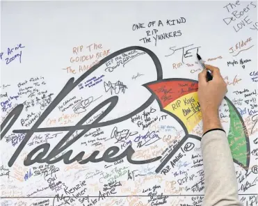  ?? ROB SCHUMACHER, USA TODAY SPORTS ?? Spectators signed a wall Wednesday to pay tribute to Arnold Palmer during a practice round for the Ryder Cup at Hazeltine National Golf Club.