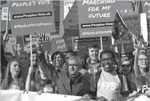  ??  ?? London Mayor Sadiq Khan, front center, holds a klaxon horn as he joins protesters Saturday. Hundreds of thousands of protesters marched through central London to demand a new referendum on Britain’s impending departure from the European Union.