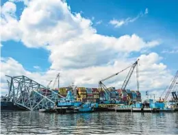  ?? JERRY JACKSON/STAFF ?? Crane barges surround the container ship Dali and the wreckage of the Francis Scott Key Bridge two weeks after the catastroph­ic collapse.