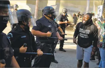  ?? Wally Skalij Los Angeles Times ?? A PROTESTER confronts Los Angeles Police Department officers in downtown L.A. on May 29.