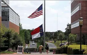  ?? TRAVIS DOVE — THE NEW YORK TIMES ?? Flags fly at half-staff on the University of North Carolina at Charlotte campus Wednesday, one day after a gunman opened fire on students in an anthropolo­gy class, killing two and injuring four others.