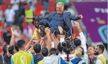  ?? FOTO: ADRIAN DENNIS/AFP ?? Unbändige Freude über den 2:0-Sieg: Die iranischen Spieler lassen Trainer Carlos Queiroz hochleben.